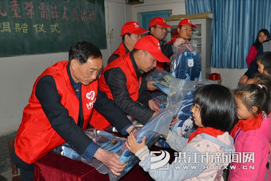 志愿者在硖洲小学为留守儿童发放学习用品(杨锡建摄)