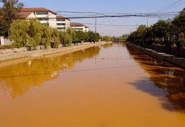 黄色污水流经路段都是居民聚居区,给百姓生活造成了很大困扰,图为孝妇河黄色污水映照下的居民小区。