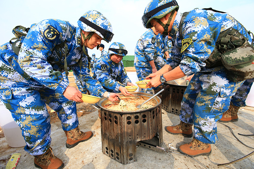 2月24日,海军陆战队官兵乘专列抵达北京军区某训练基地后进行野餐。新华社记者 查春明摄