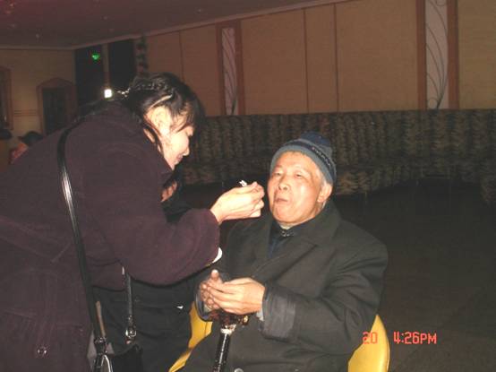 第五支部主委胡静中在给老盟员喂蛋糕.JPG